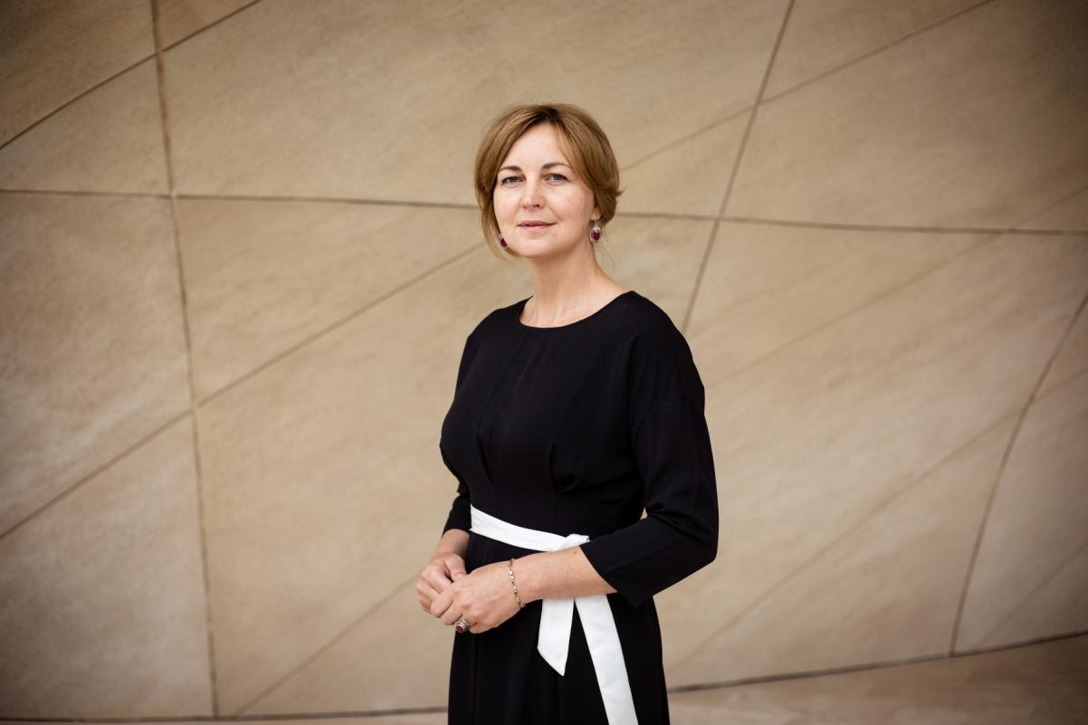Liliya Stadnik stoi na tle ściany w Muzeum POLIN.