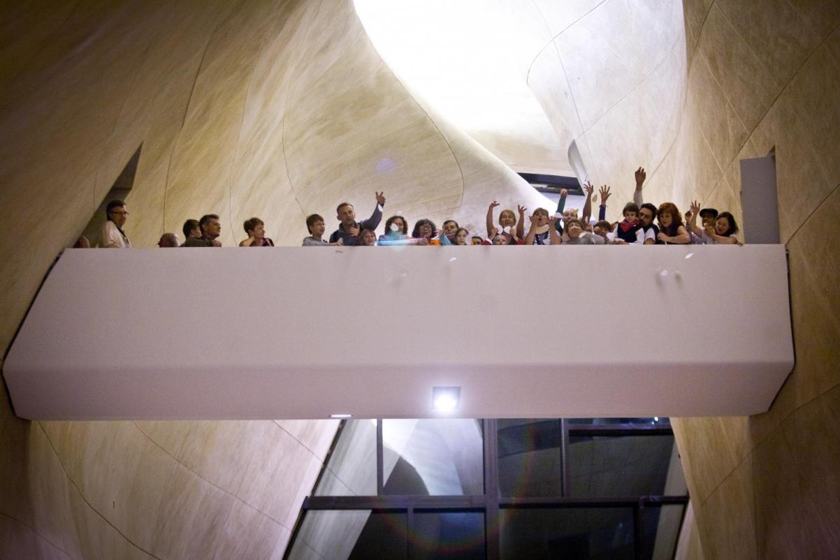 Grupa ludzi stoi na mostku w Muzeum POLIN podczas Nocy Muzeów 2013.