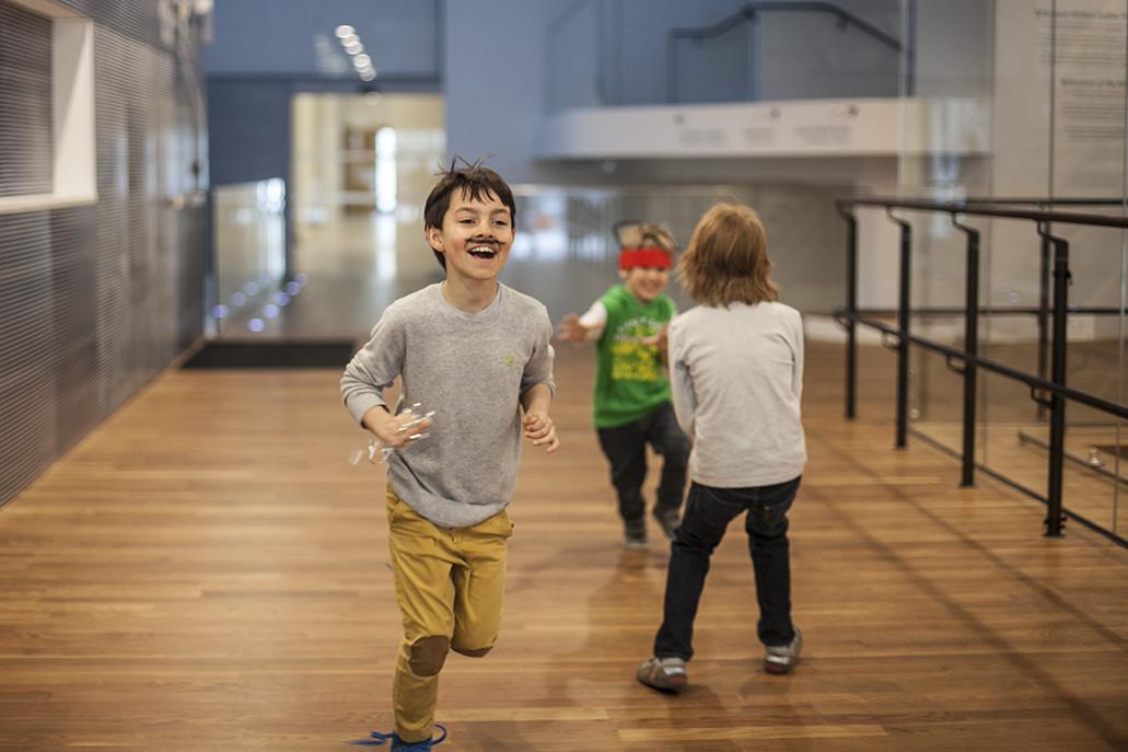 Rozbawione dzieci biegają po muzeum podczas balu purimowego.