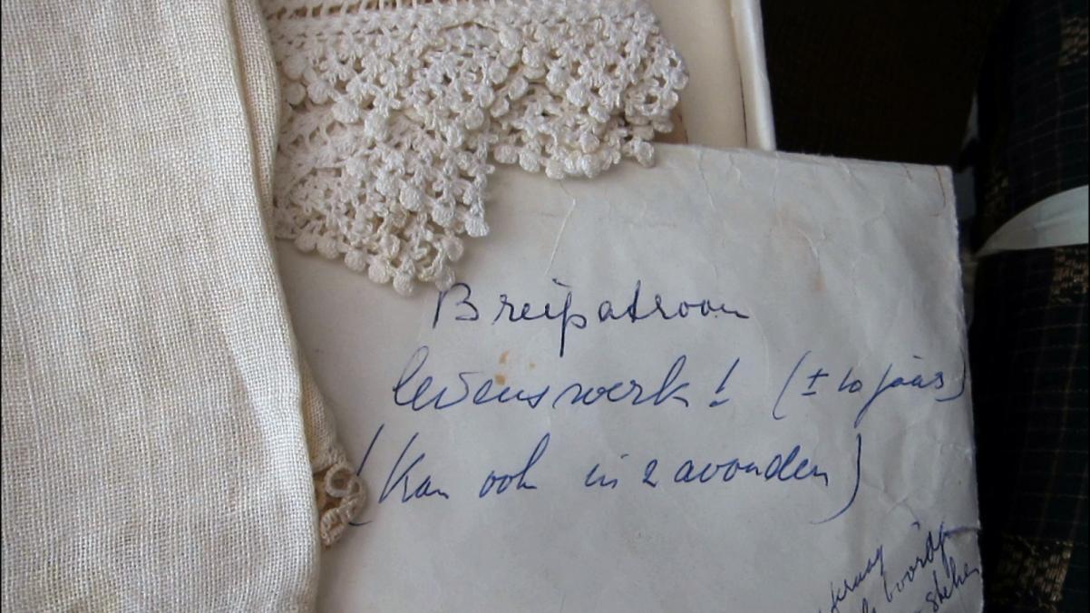 Na stoliku zasłanym obrusem leży zapisana odręcznie kartka.