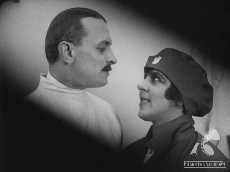 Kadr z filmu "Cud nad Wisłą". Mężczyzna z wąsem i kobieta w berecie patrzą sobie w oczy.