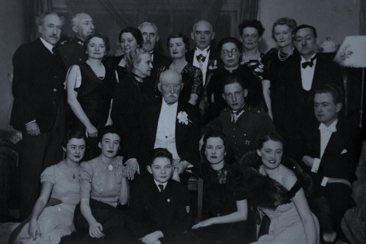 Czarno-białe zdjęcie grupy osób w wieczorowych strojach.