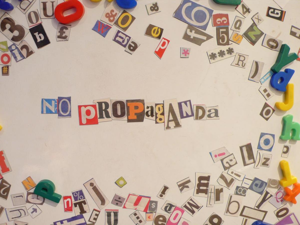 Kartka papieru, na której ułożony jest napis z wyciętych literek z gazet: no propaganda.