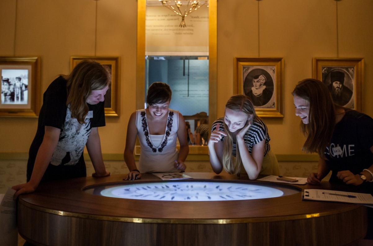 Wystawa stała w Muzeum POLIN. Cztery kobiety oglądają coś na ekranie multimedialnym.
