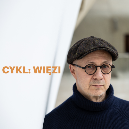 Mikołaj Grynberg stoi w holu głównym Muzeum POLIN. Ma okulary i kaszkiet. Obok złoty napis cykl: "Więzi".