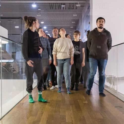 A group of people walks down the corridor through the POLIN Museum.