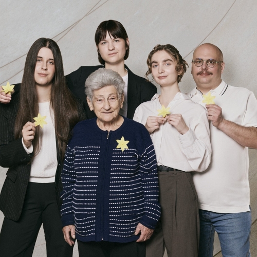 Krystyna Budnicka stoi w holu muzeum z czworgiem wolontariuszy akcji Żonkile.